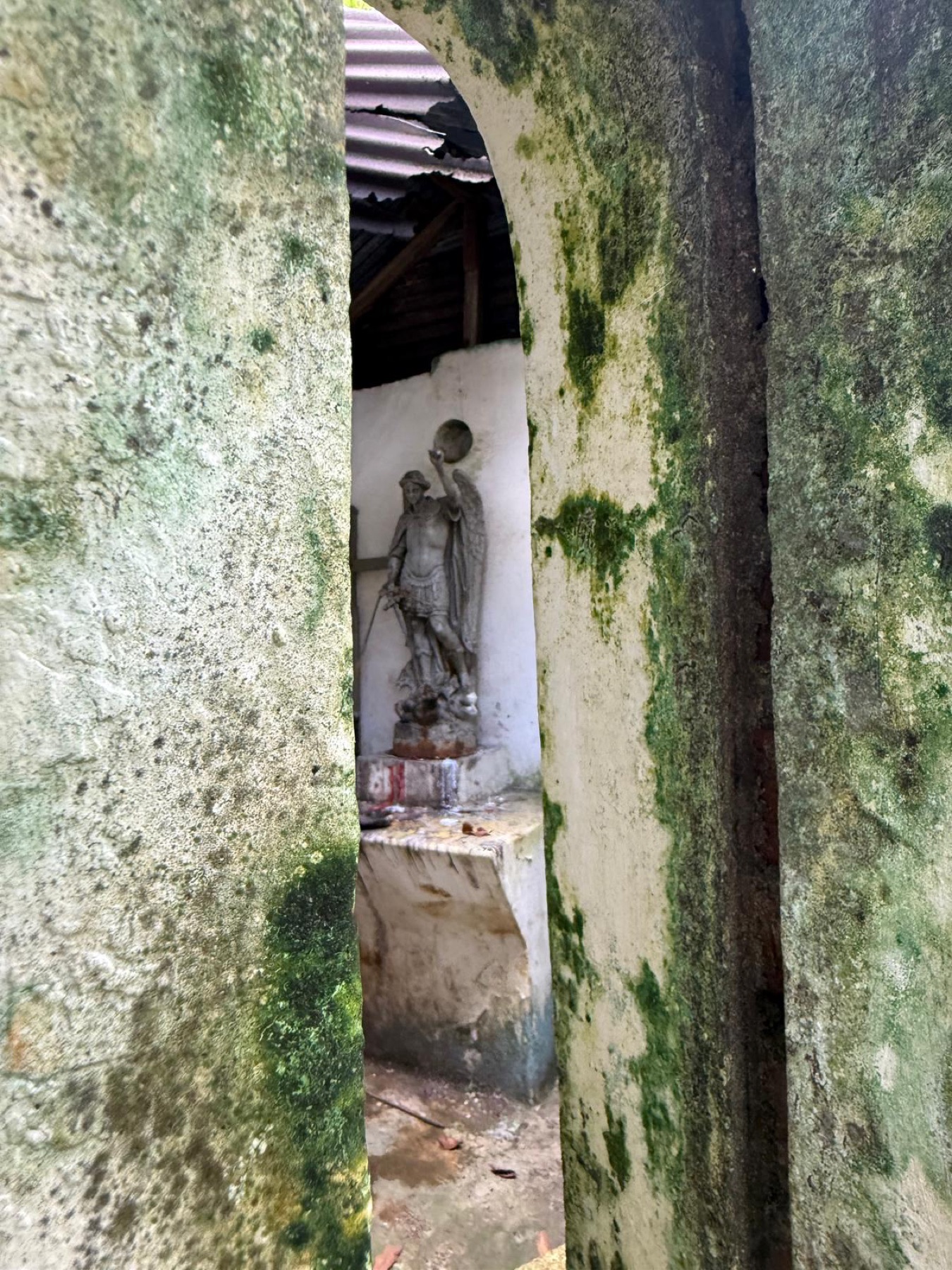 Statue framed by mossy walls